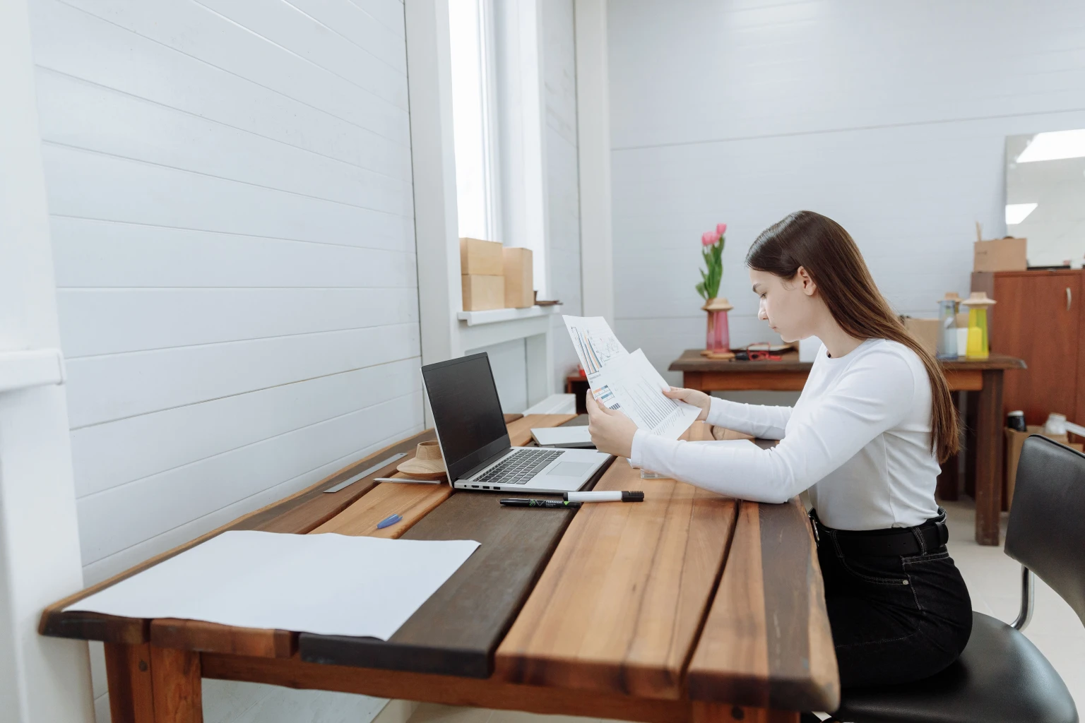 Laptop en gedrukte pagina's die naast elkaar worden vergeleken bij helder daglicht
